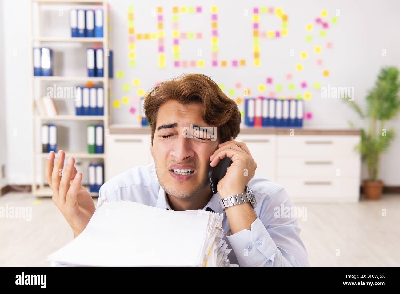 Young employee suffering from excessive work Stock Photo
