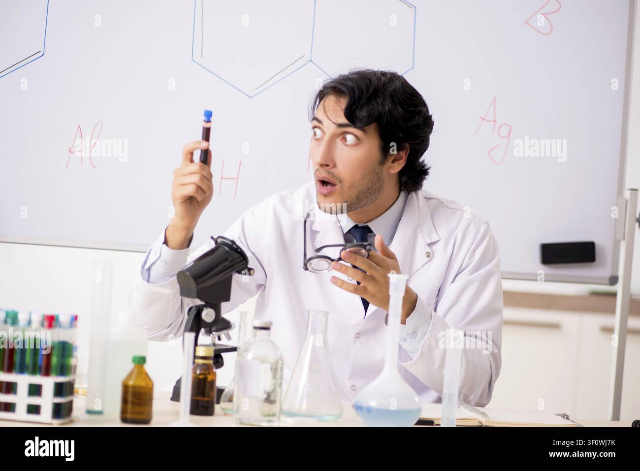 Young funny chemist in front of white board Stock Photo