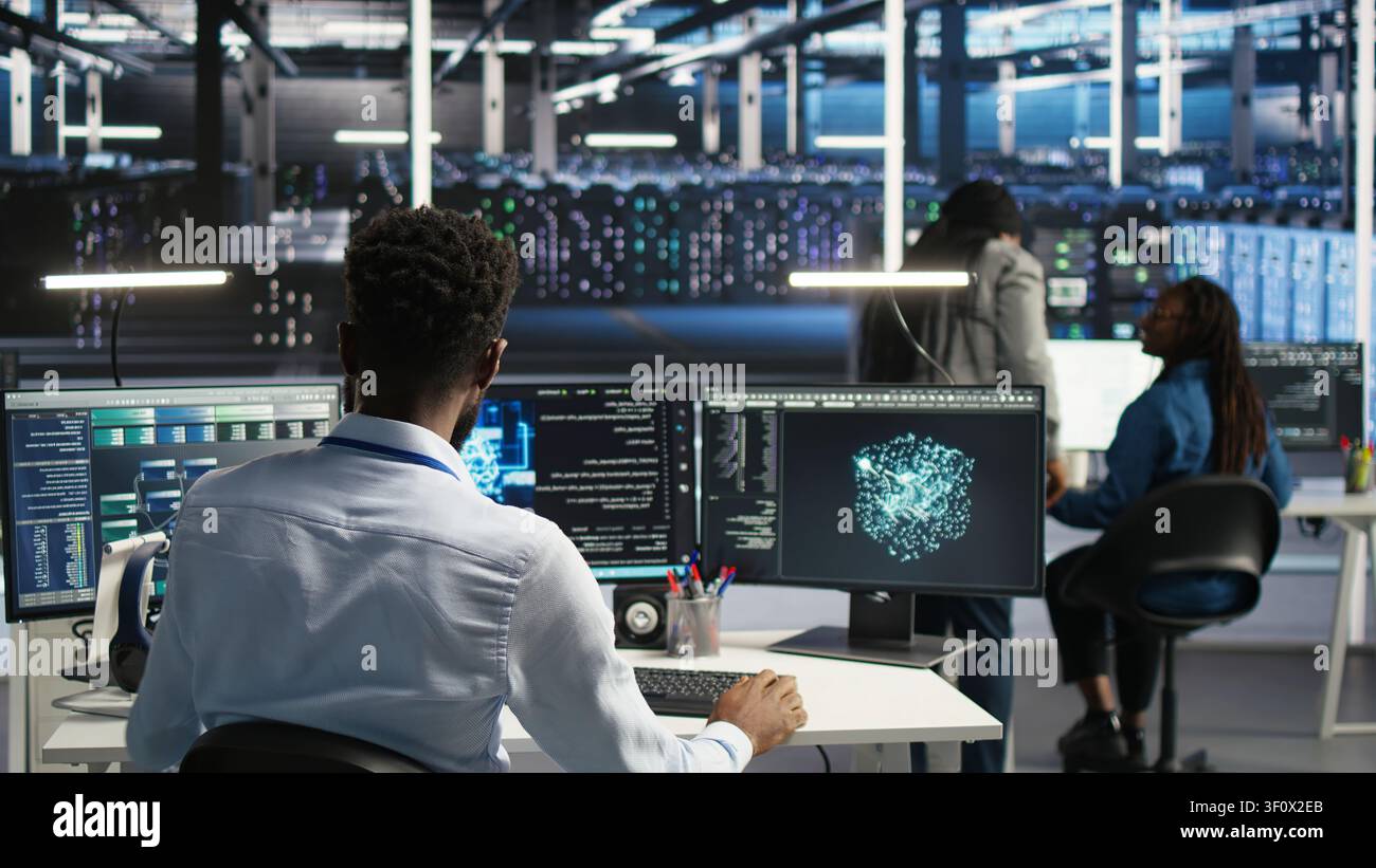 Supervisor supervising server facility systems engineer working with AI neural network models to set up hardware. Stock Photo