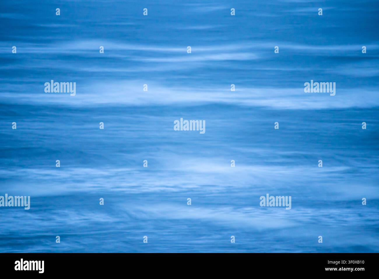 Sea texture rendered in tranquil blue tones with subtle wave lines Stock Photo