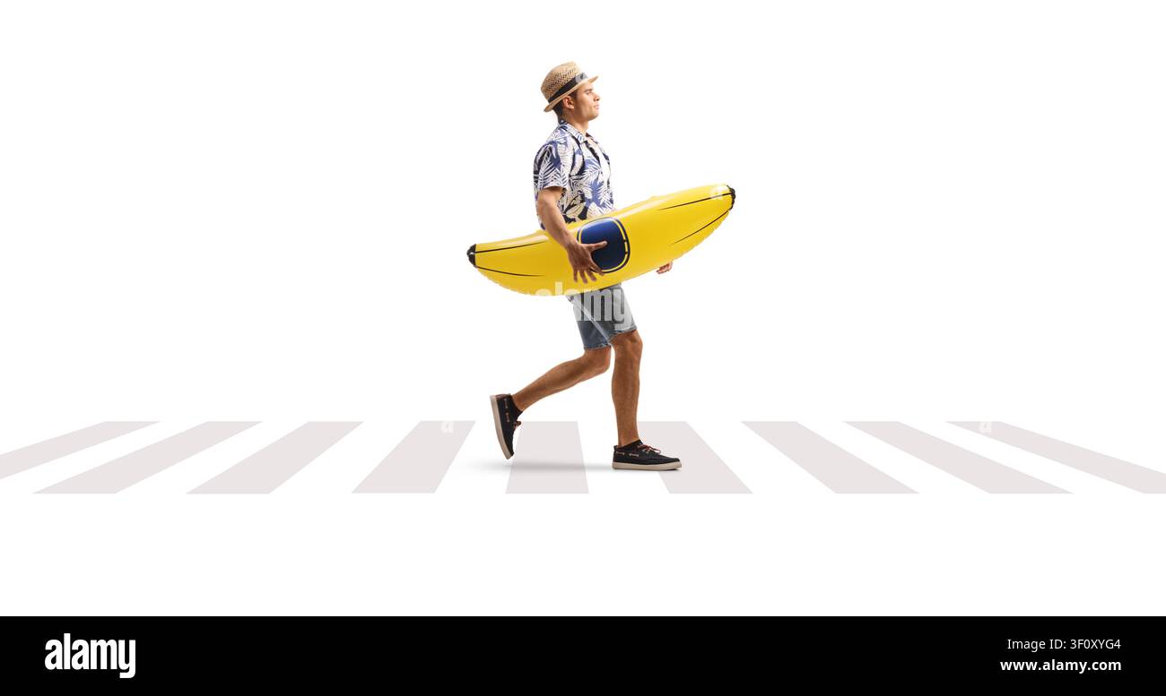 Man carrying a banana pool float at a zebra crossing isolated on white background Stock Photo