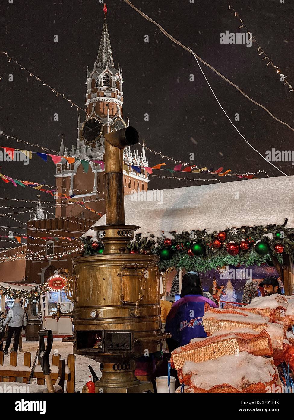 Moscow, Russia - January 22 2022: Traditional samovar at festive Christmas market with Kremlin tower in snowfall - Smartphone Captured Stock Image