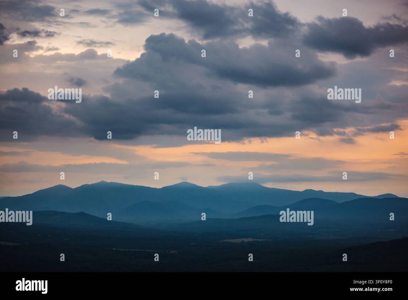 Dramatic stormy sunset over a hazy blue mountain range Stock Photo