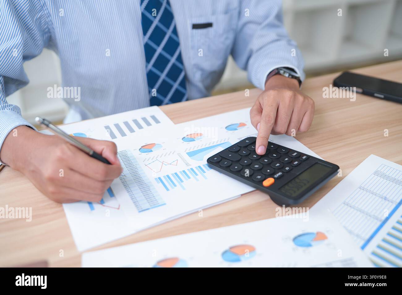 Business Accountant Analyzing Financial Reports with Calculator Stock Photo