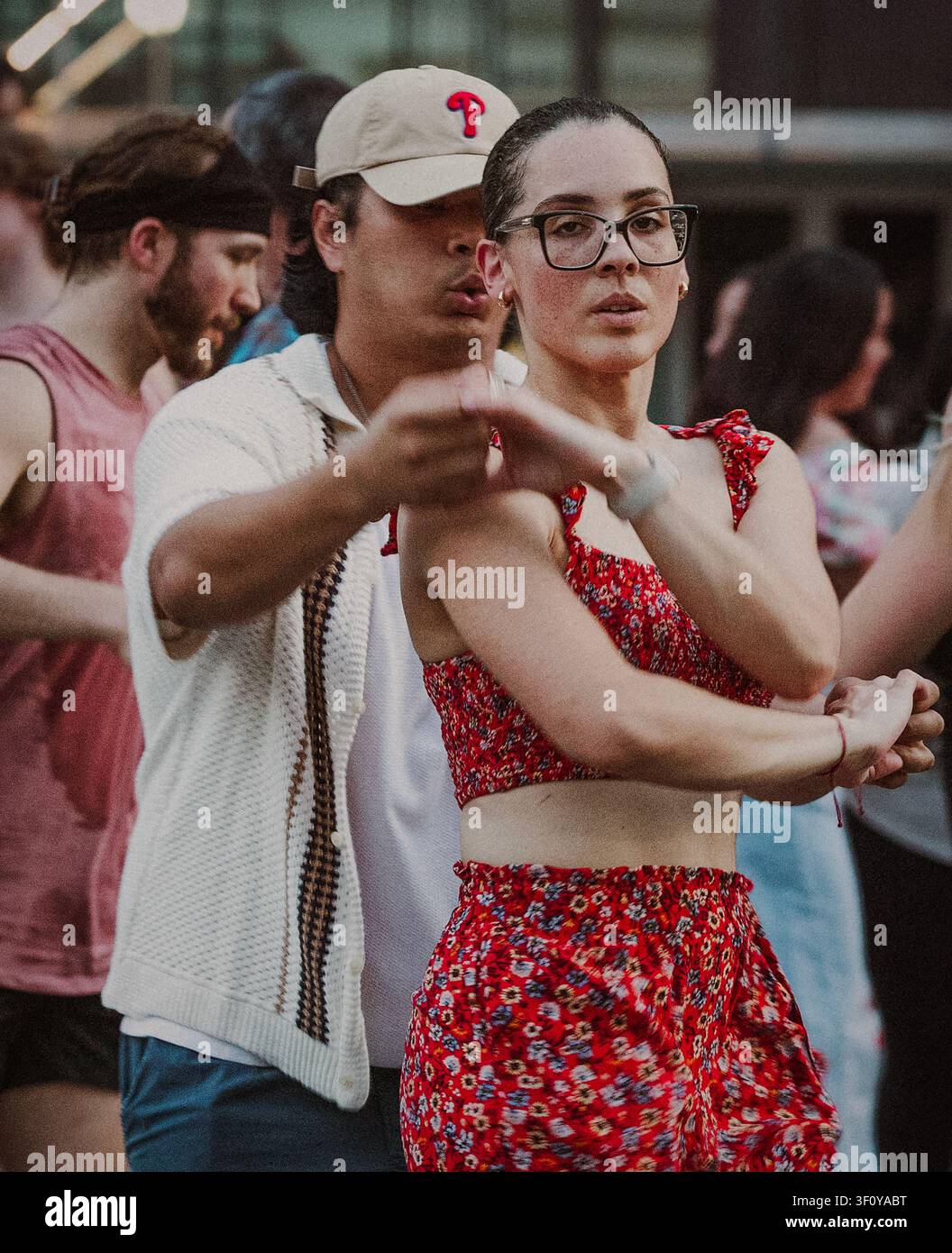 Young woman in glasses learning partner dance moves Stock Photo