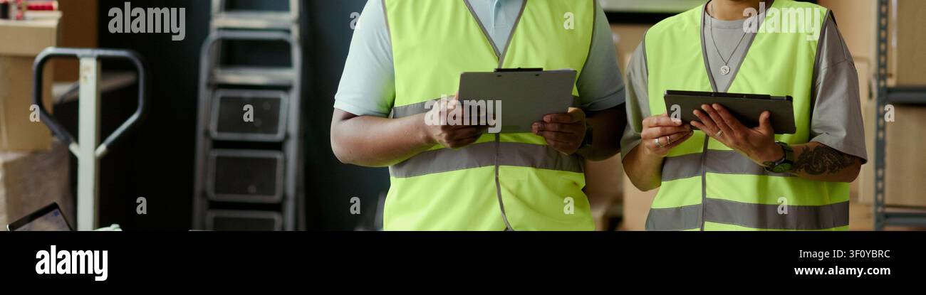 Header of warehouse workers checking inventory on tablets, coordinating stock control and logistics workflow in storage facility. Useful for supply chain, fulfillment, retail operations marketing Stock Photo