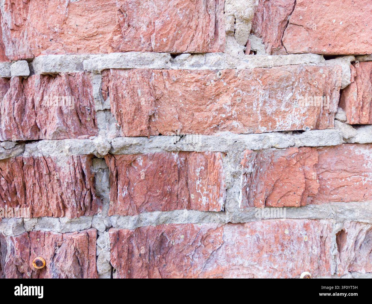 Old red brick wall with visible cracks Stock Photo
