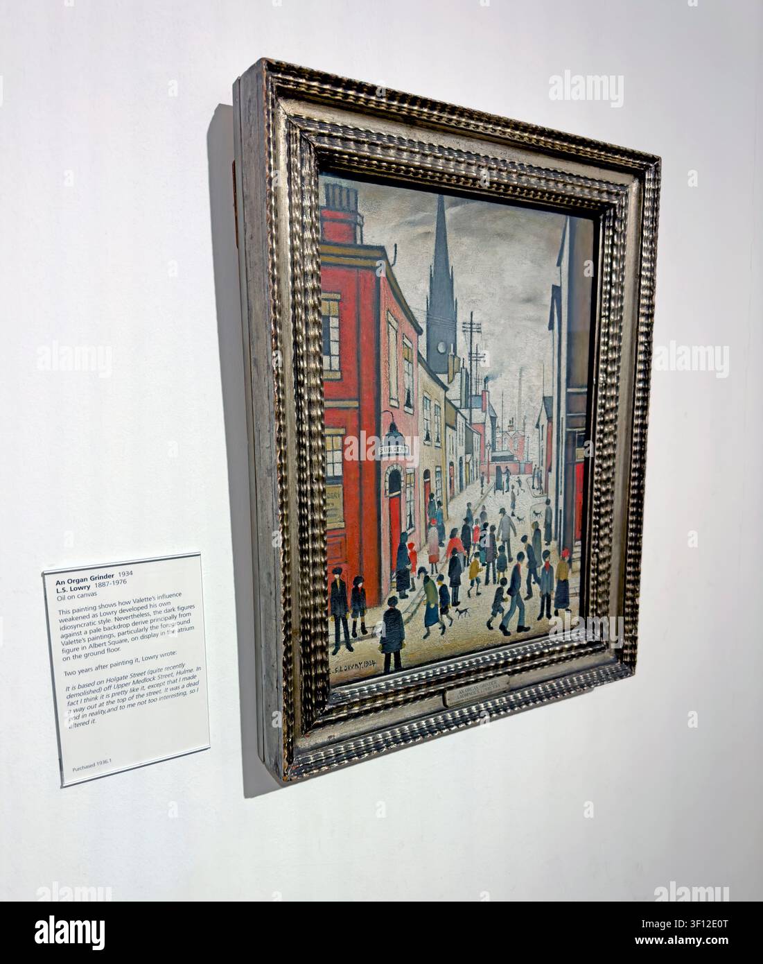 An Organ Grinder framed LS Lowry painting displayed on a white gallery wall in manchester, UK. Stock Photo