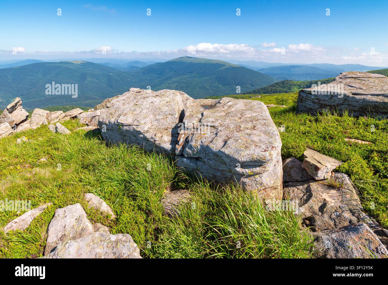 mountain landscape with grass and rock on a slope. view in to the distant valley of carpathian mountains. mountainous scenery of ukraine in summer. gr Stock Photo