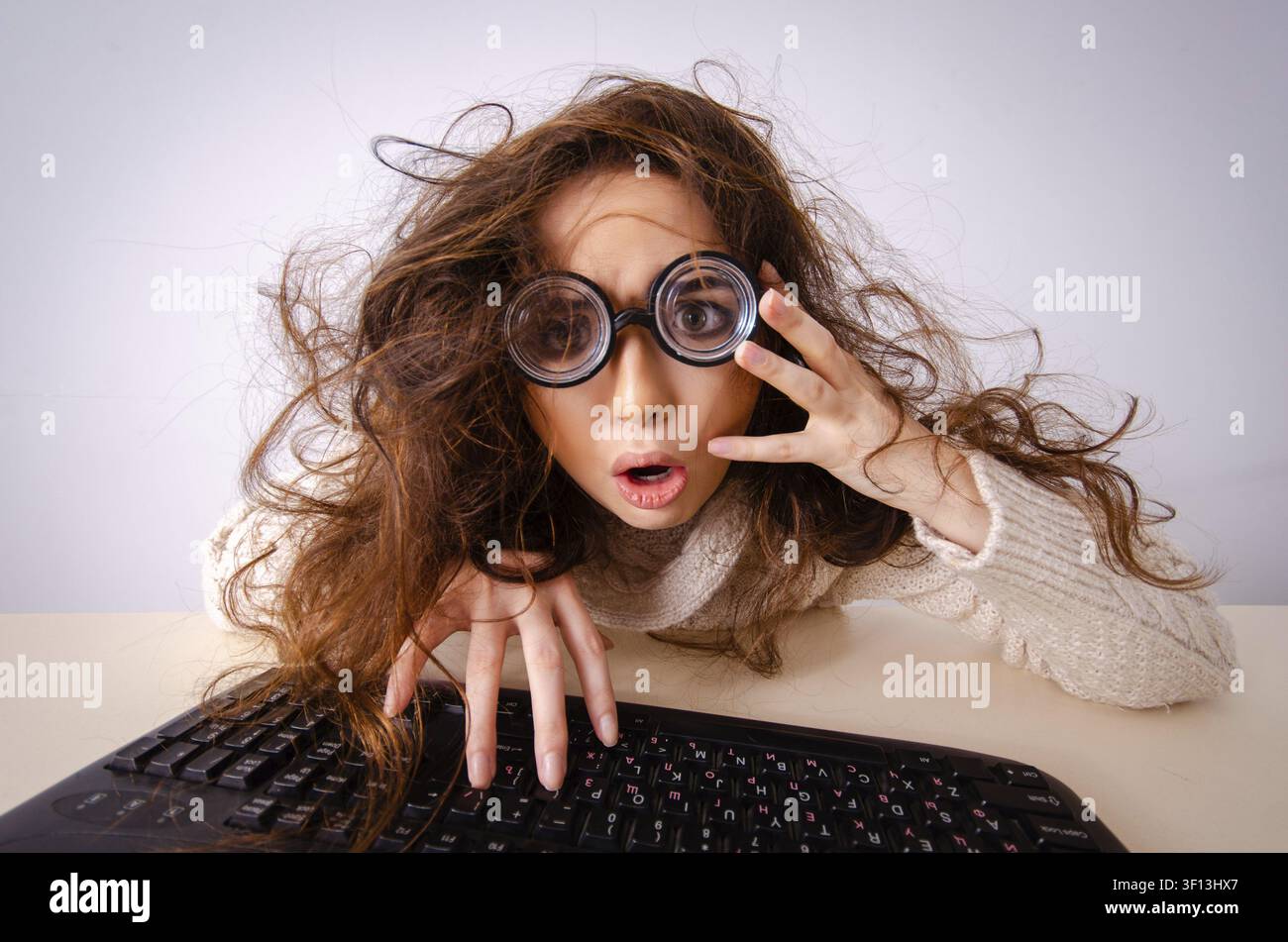 Funny nerd girl working on computer Stock Photo
