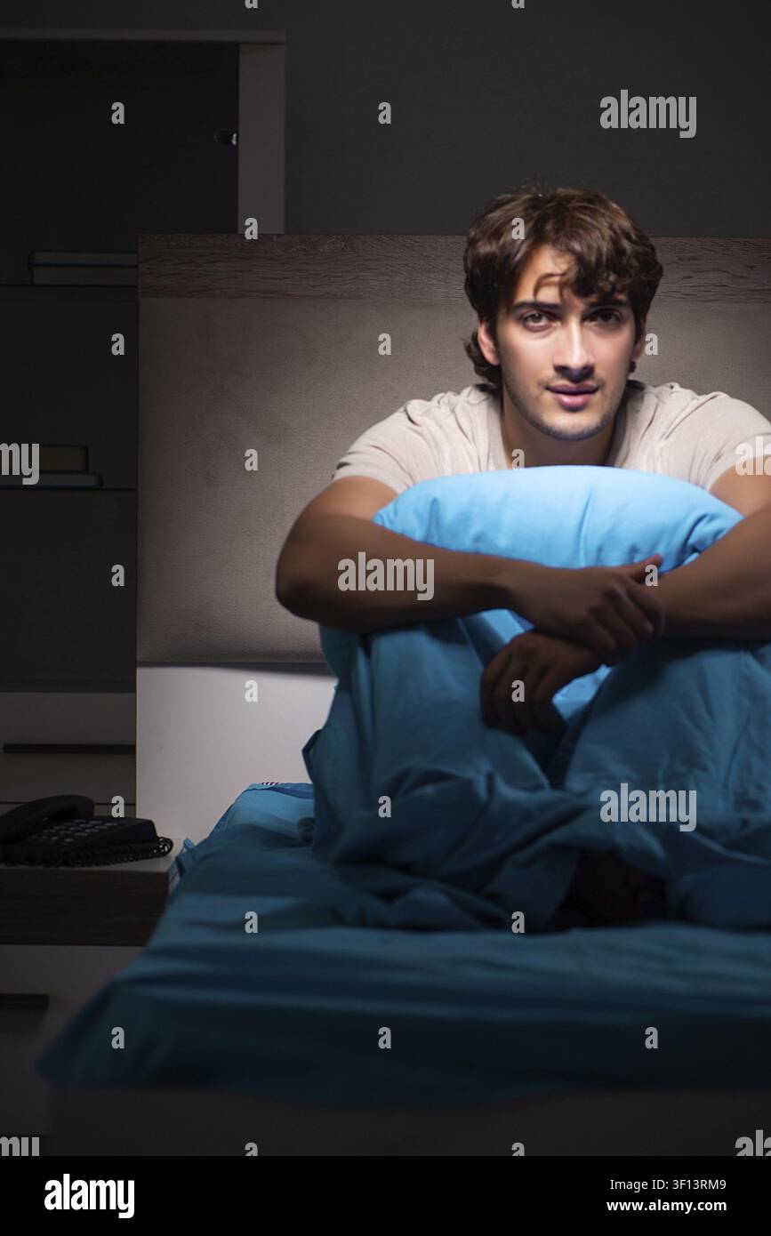 Young handsome man suffering from insomnia in bed Stock Photo
