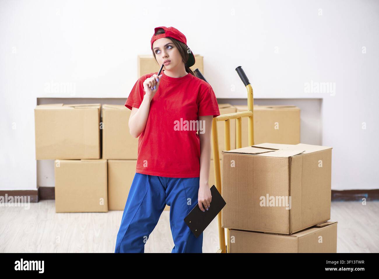 Young female professional mover doing home relocation Stock Photo