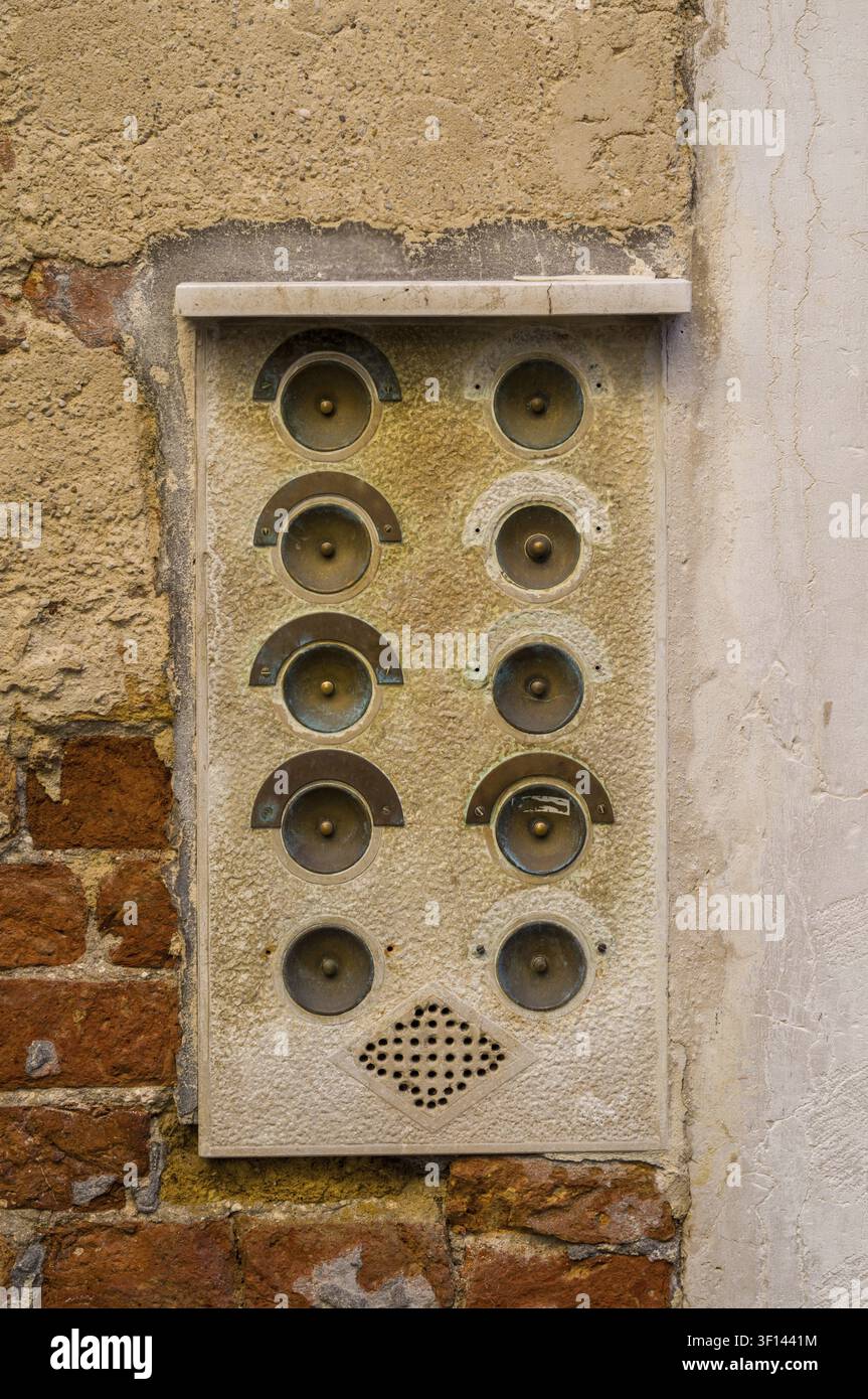 Vintage intercom with multiple buttons mounted on a stucco wall, part brick Stock Photo