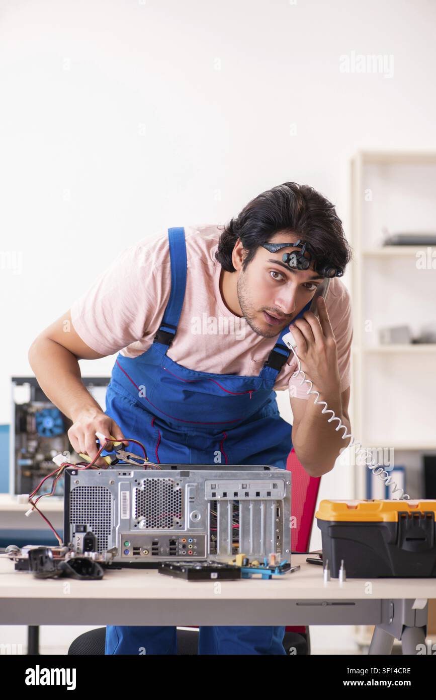 Young male contractor repairing computer Stock Photo