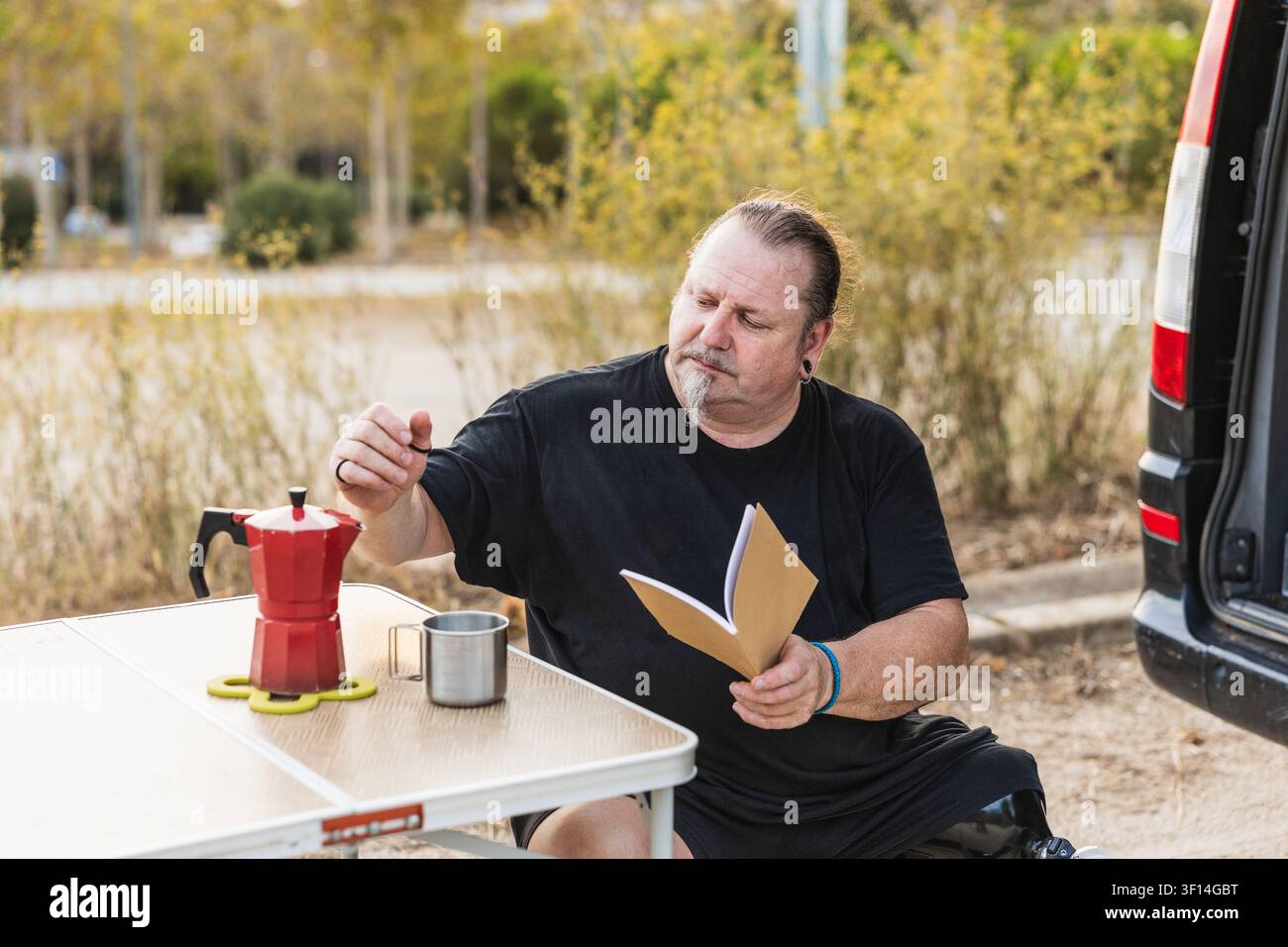 Man with prosthetic leg enjoying coffee while camping Stock Photo