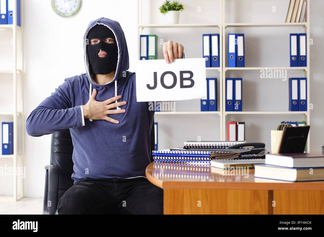 Male thief in balaclava in the office Stock Photo
