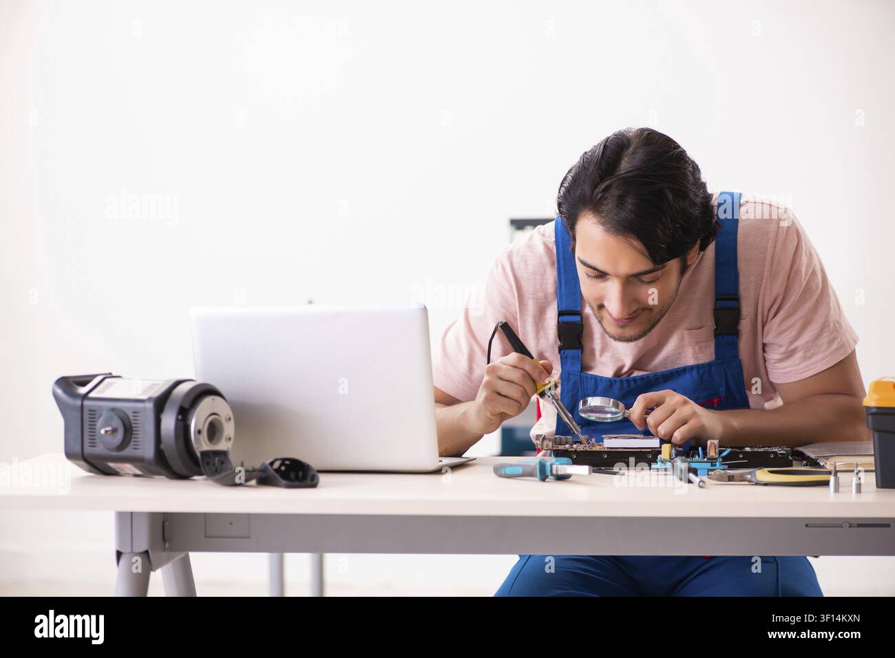 Young male contractor repairing computer Stock Photo