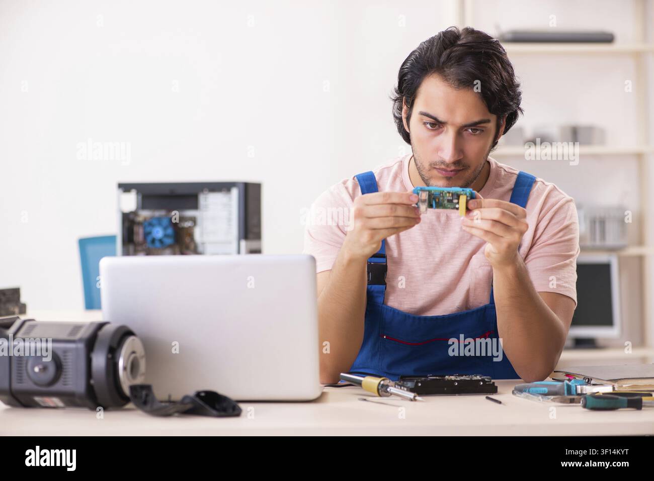 Young male contractor repairing computer Stock Photo