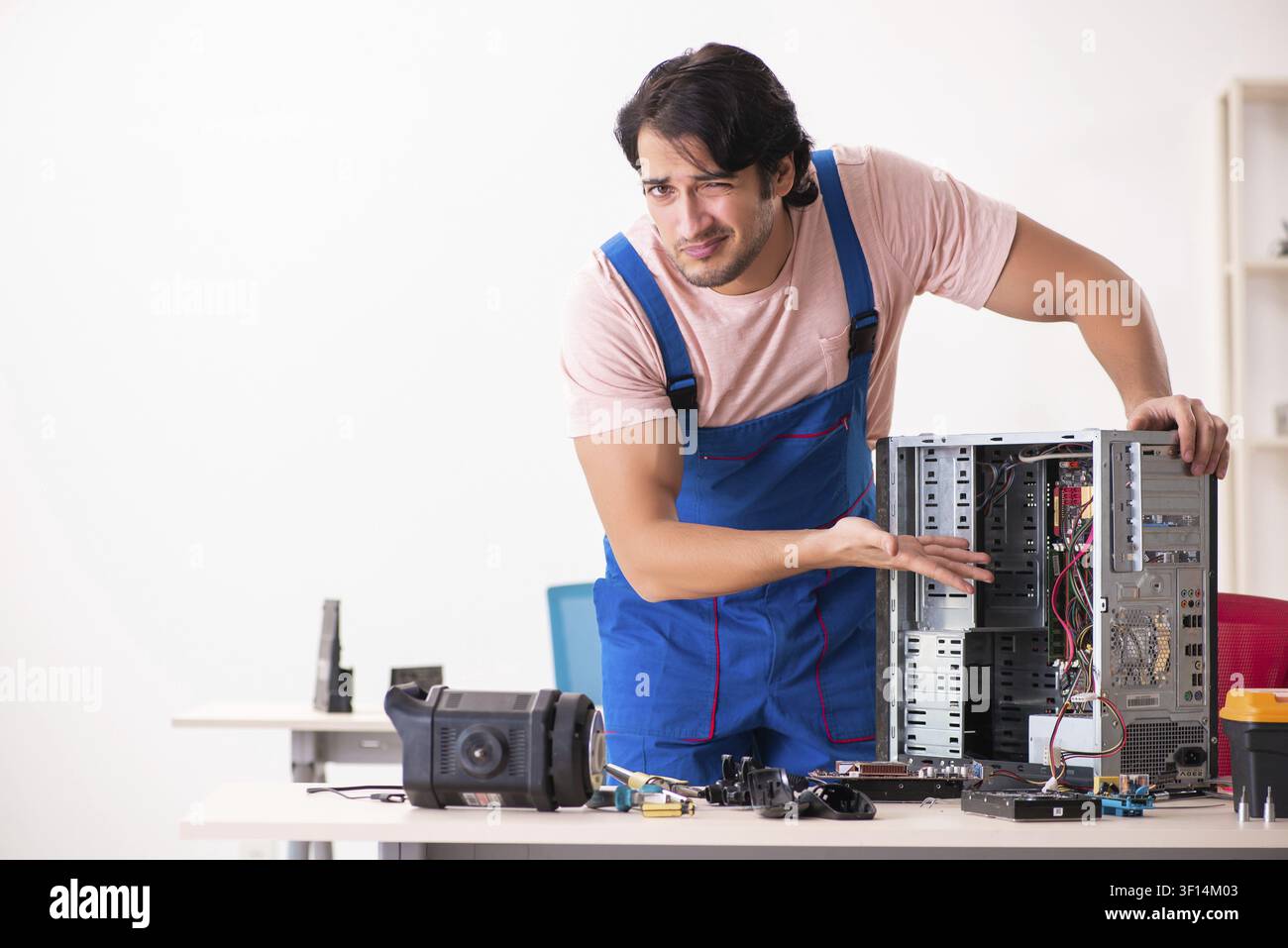 Young male contractor repairing computer Stock Photo