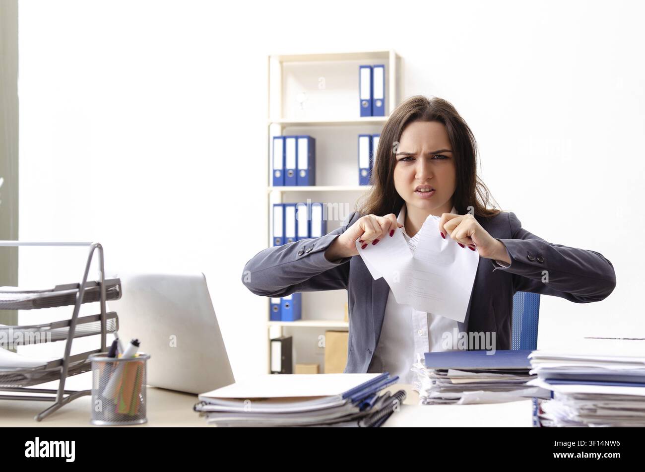 Young female employee unhappy with excessive work Stock Photo