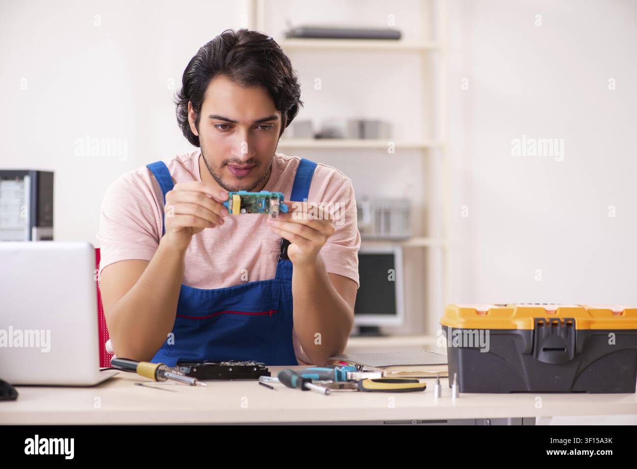 Young male contractor repairing computer Stock Photo