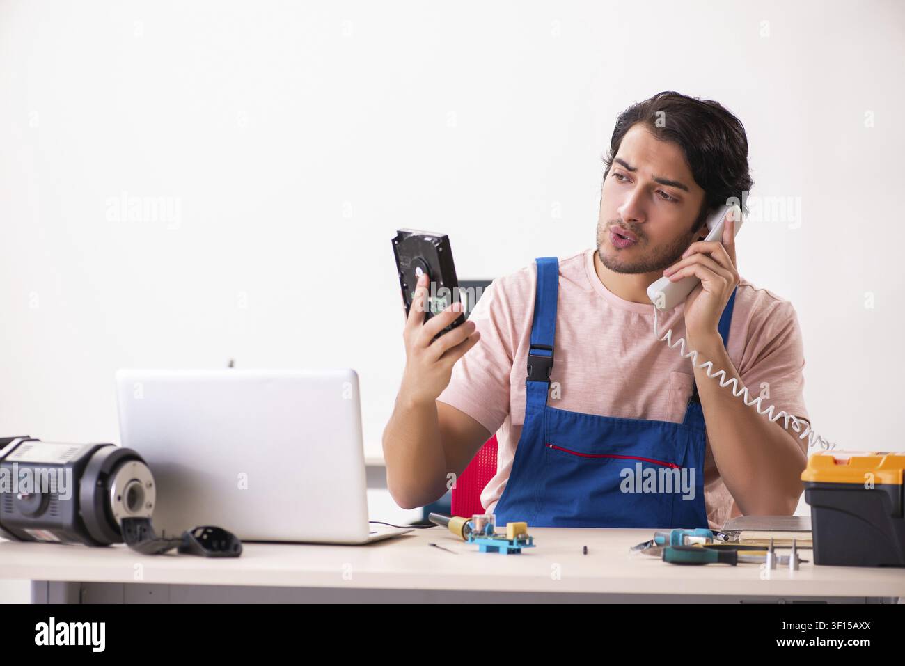 Young male contractor repairing computer Stock Photo