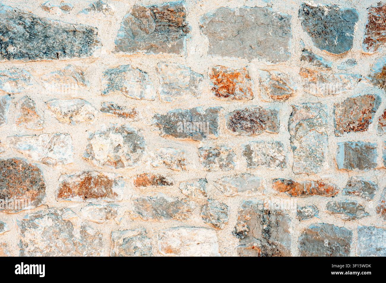 Weathered stone wall texture with natural limestone masonry background. Stock Photo