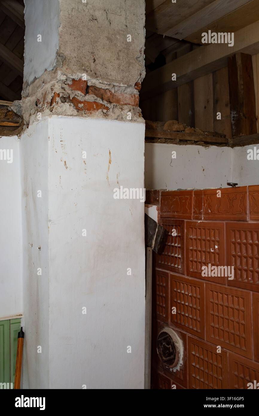 Old Brick Chimney Demolition and Restoration with Vintage Tiled  Stove Stock Photo