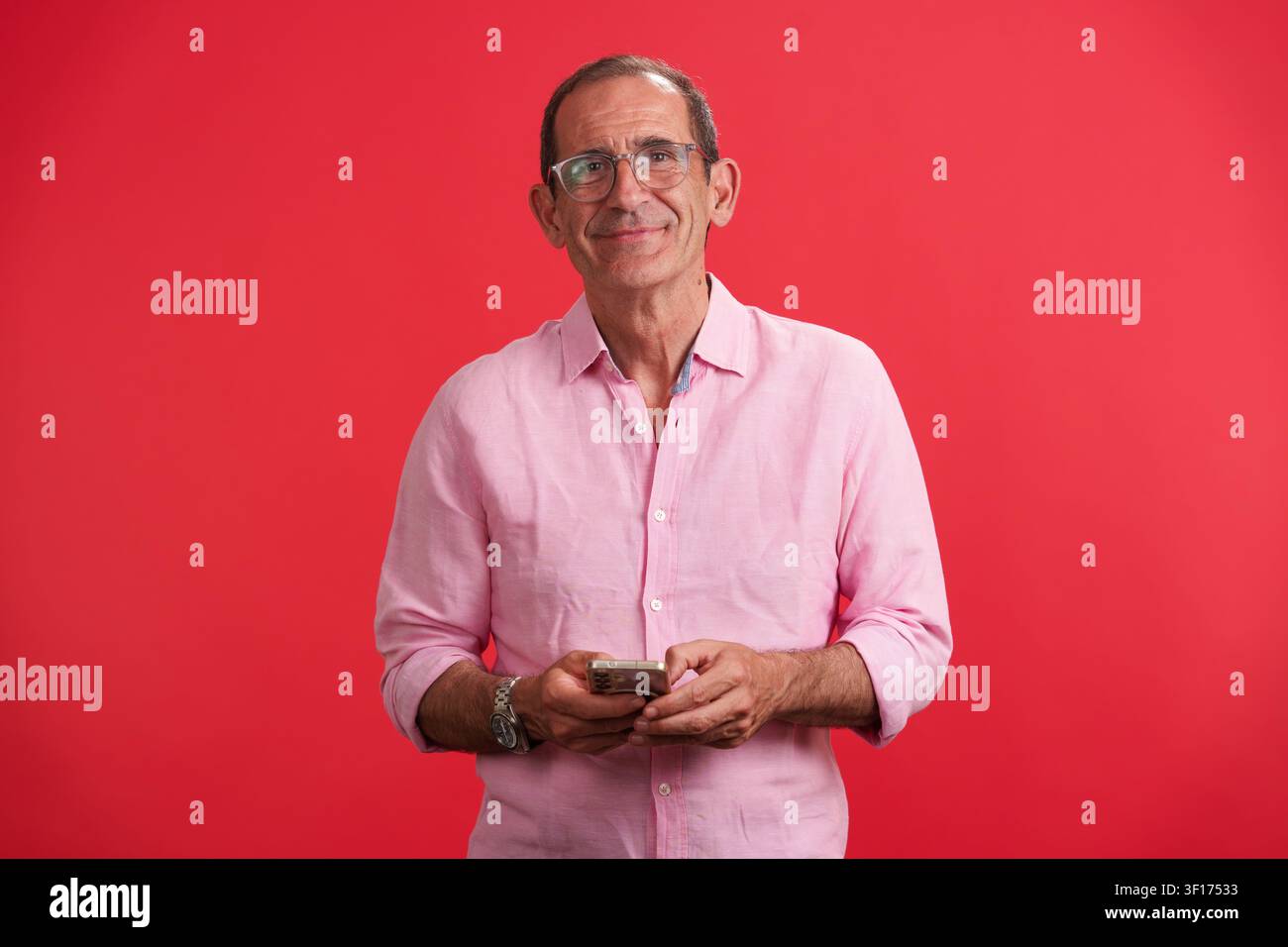Mature man smiling using smartphone for positive longevity Stock Photo