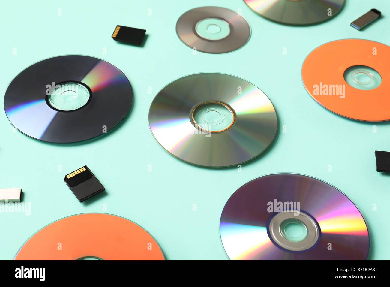 Composition with CD disks, USB flash drives and SD cards on turquoise background Stock Photo