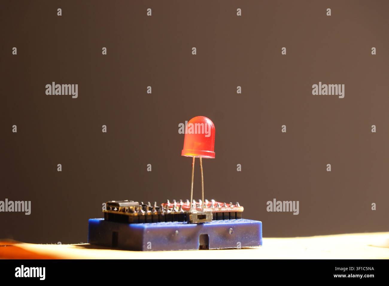 Red led connected on blue circuit board with microcontroller for electronics project Stock Photo