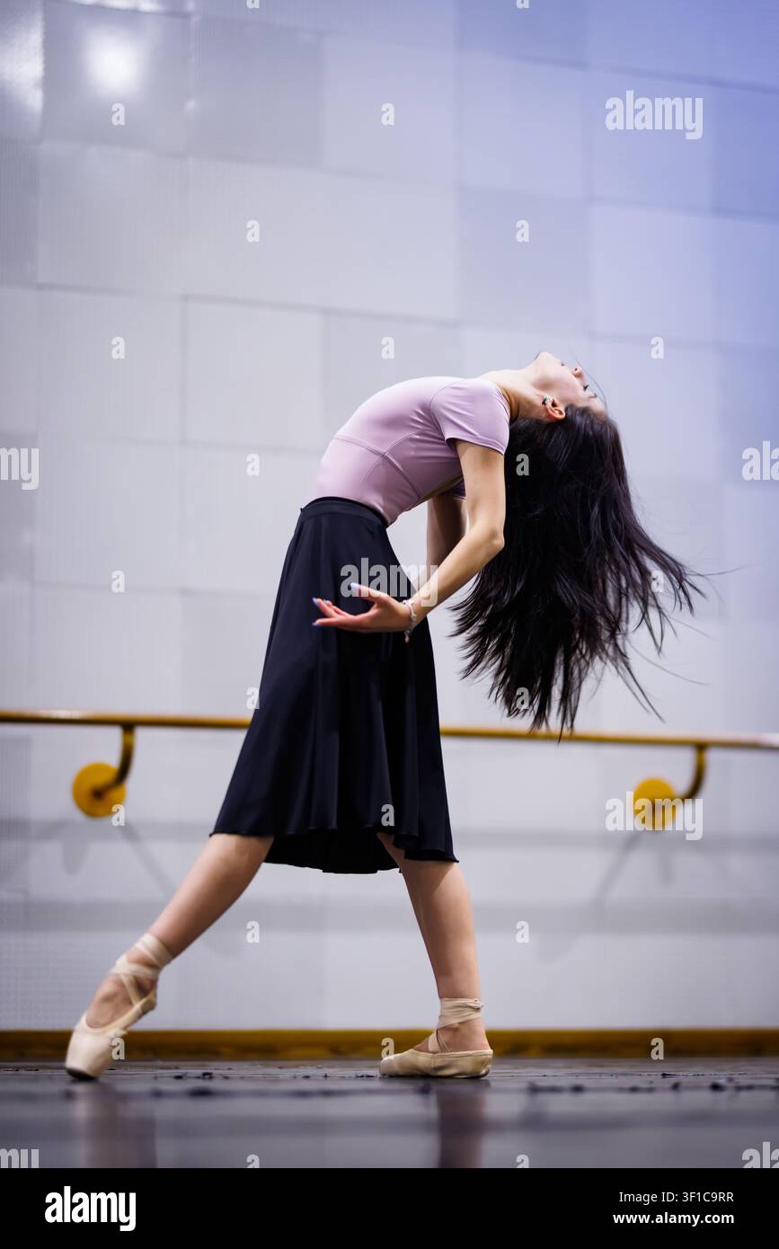 Dancer performs an expressive movement in a dance studio during a rehearsal session Stock Photo