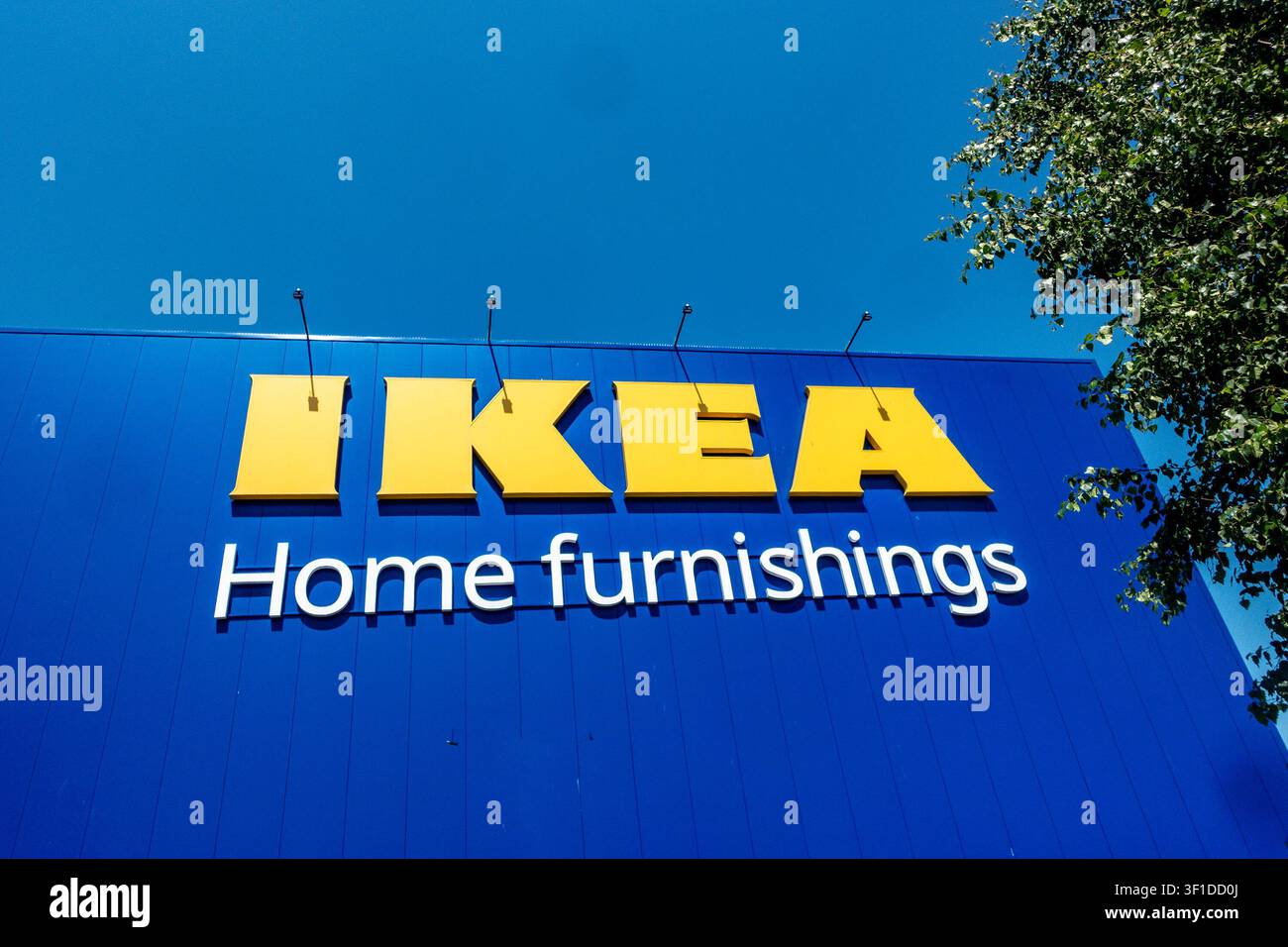 Large yellow IKEA and white Home furnishings sign on a blue building facade in Ballymun, Dublin, Ireland, under a clear blue sky. Stock Photo