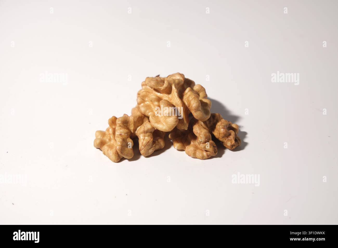 Shelled walnut halves arranged on white background close-up Stock Photo