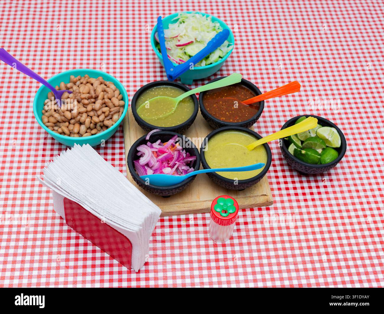Authentic Mexican sauces and beans served in small bowls on a checkered tablecloth Stock Photo
