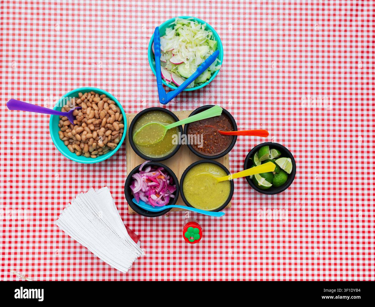 Authentic Mexican sauces and beans served in small bowls on a checkered tablecloth Stock Photo