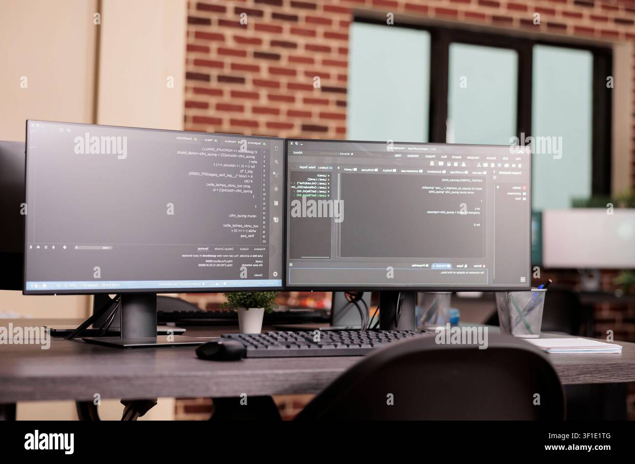 Empty IT office desk shows computer monitors running terminal windows, artificial intelligence database scripts and server cloud computing code in a software workspace. Stock Photo