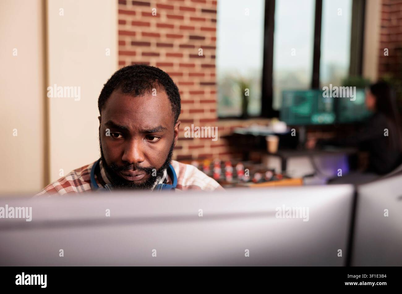Software developer programs cloud computing data at a workplace computer while creating software, writing algorithms and supporting cloud computing development in an IT office. Stock Photo