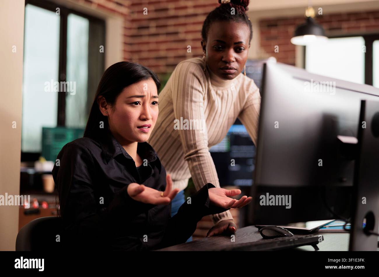 Programmers brainstorm software security ideas while developing cloud computing data, HTML scripts and algorithms on a workplace computer inside an IT office. Stock Photo