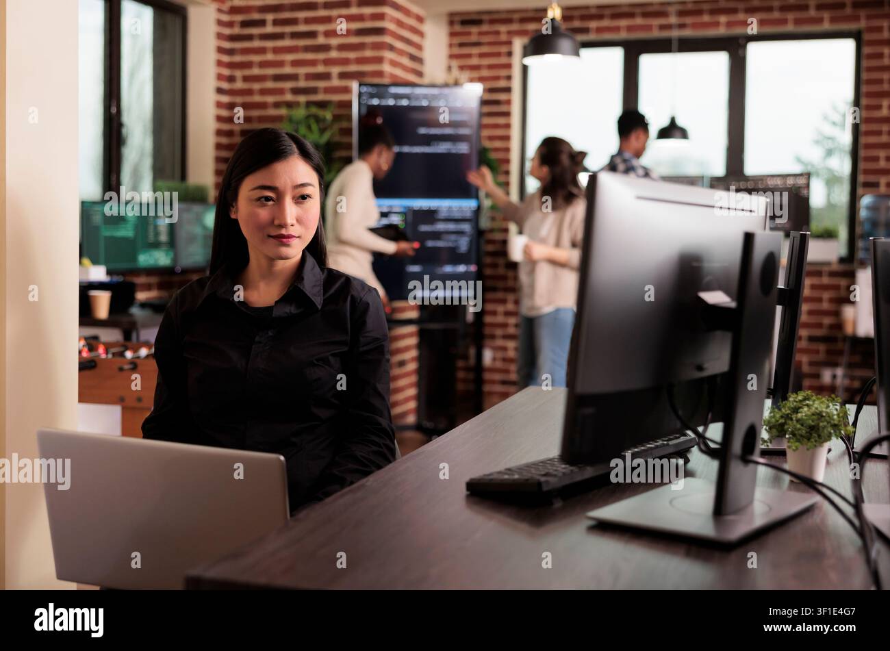 Asian programmer typing machine learning server code, sitting at desk table in it software company, programming engineer working on database system with coding script in it developing office. Stock Photo