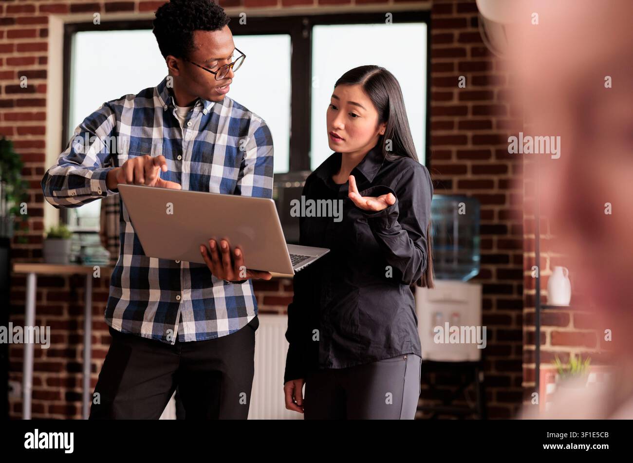 Diverse coders looking at security firewall on laptop, using html and terminal window, working in it programming office, software developers to program software using cloud computing app server. Stock Photo