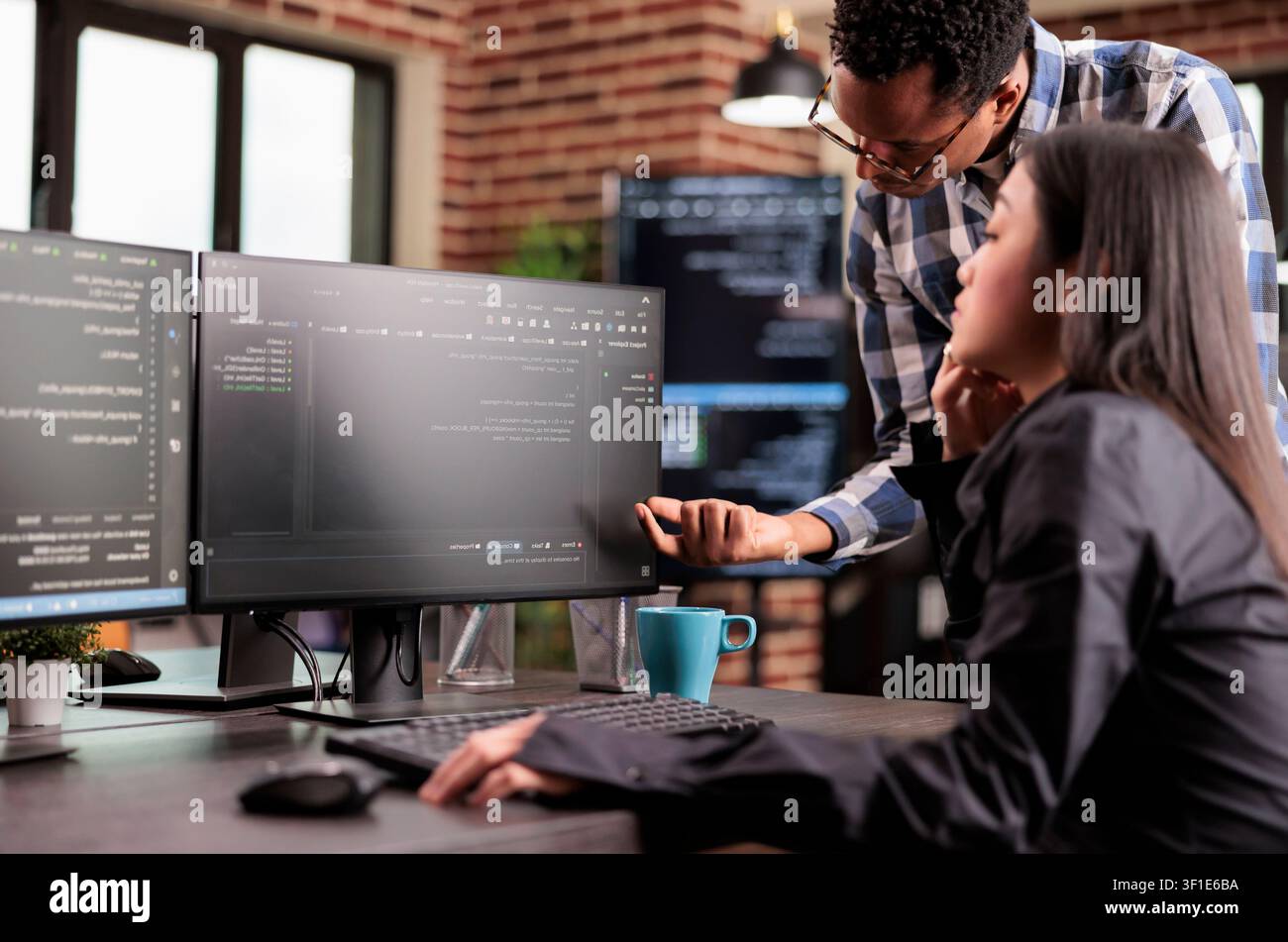 Programmers reviewing HTML code together in startup office while working with code, screens and digital infrastructure for software development. Stock Photo