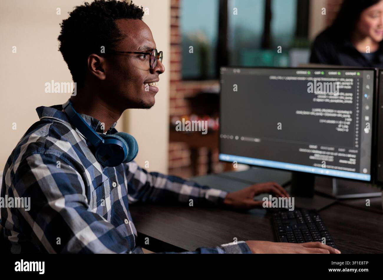 Smiling African American software engineer develops a machine learning algorithm to support system security stability and binary network encryption. Stock Photo
