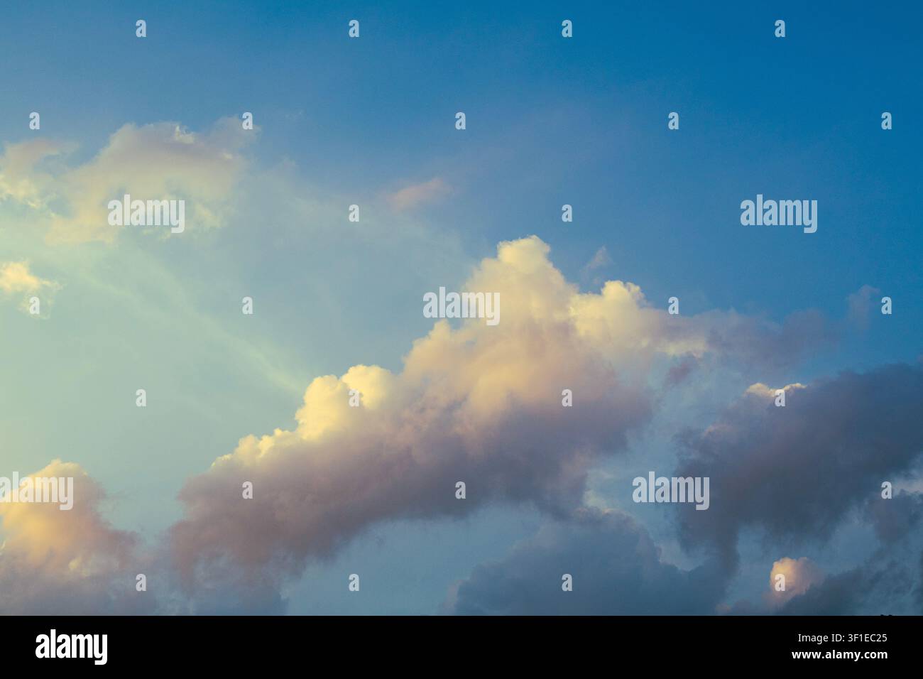Dramatic Golden Sunset Clouds with Sun Rays Breaking Through Stormy Sky Stock Photo