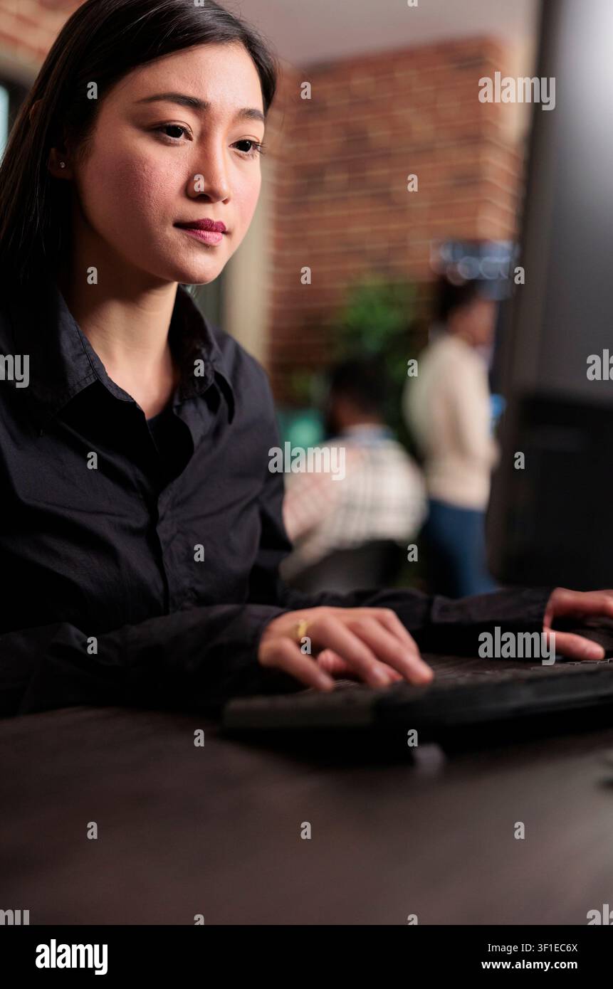 Asian system administrator updates firewall security and cloud storage encryption, maintaining stable infrastructure in a programming room, connecting security and technology within a clear. Stock Photo