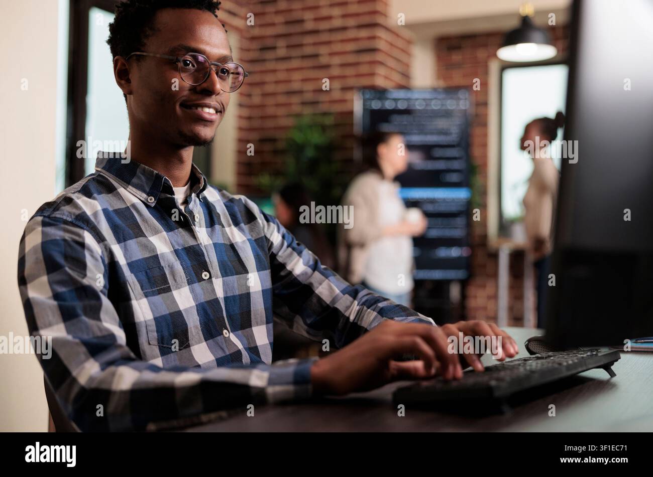 Smiling African American software engineer develops a machine learning algorithm for system security, network stability and binary encryption work. Stock Photo