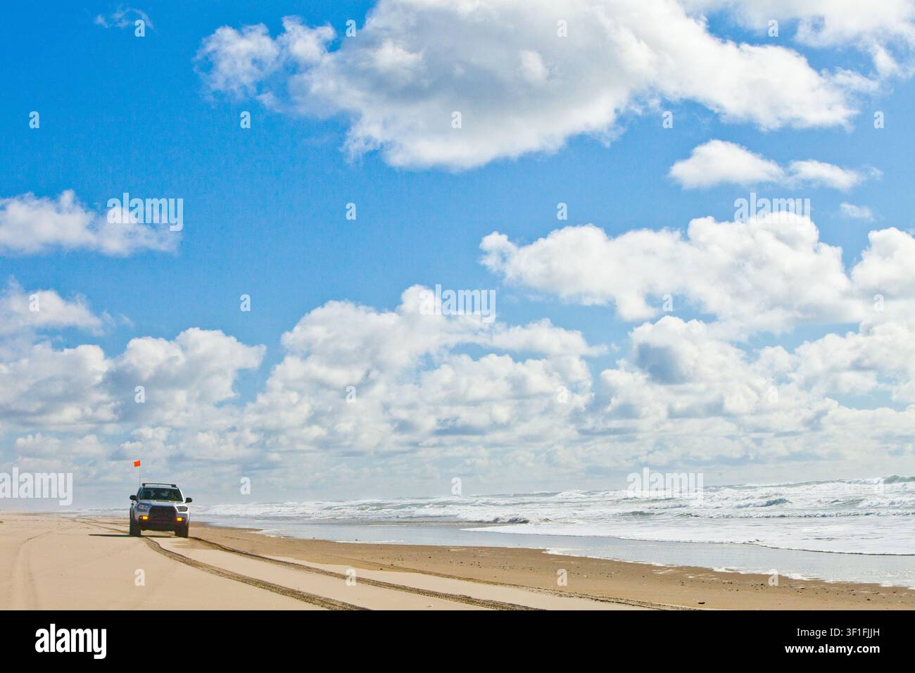 Four wheel drive vehicle exploring a sandy beach Stock Photo