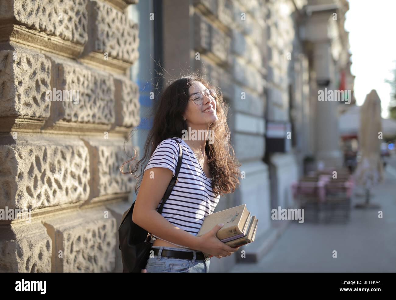 Happy female student enjoying the city sunshine Stock Photo