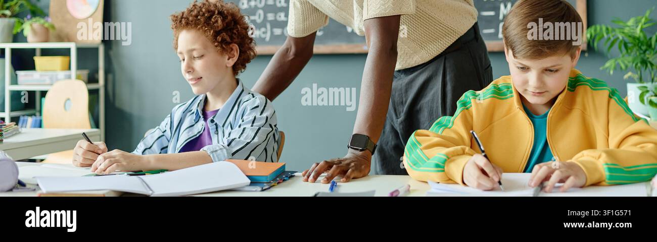 Schoolchildren Studying with Teacher Support in Classroom Stock Photo