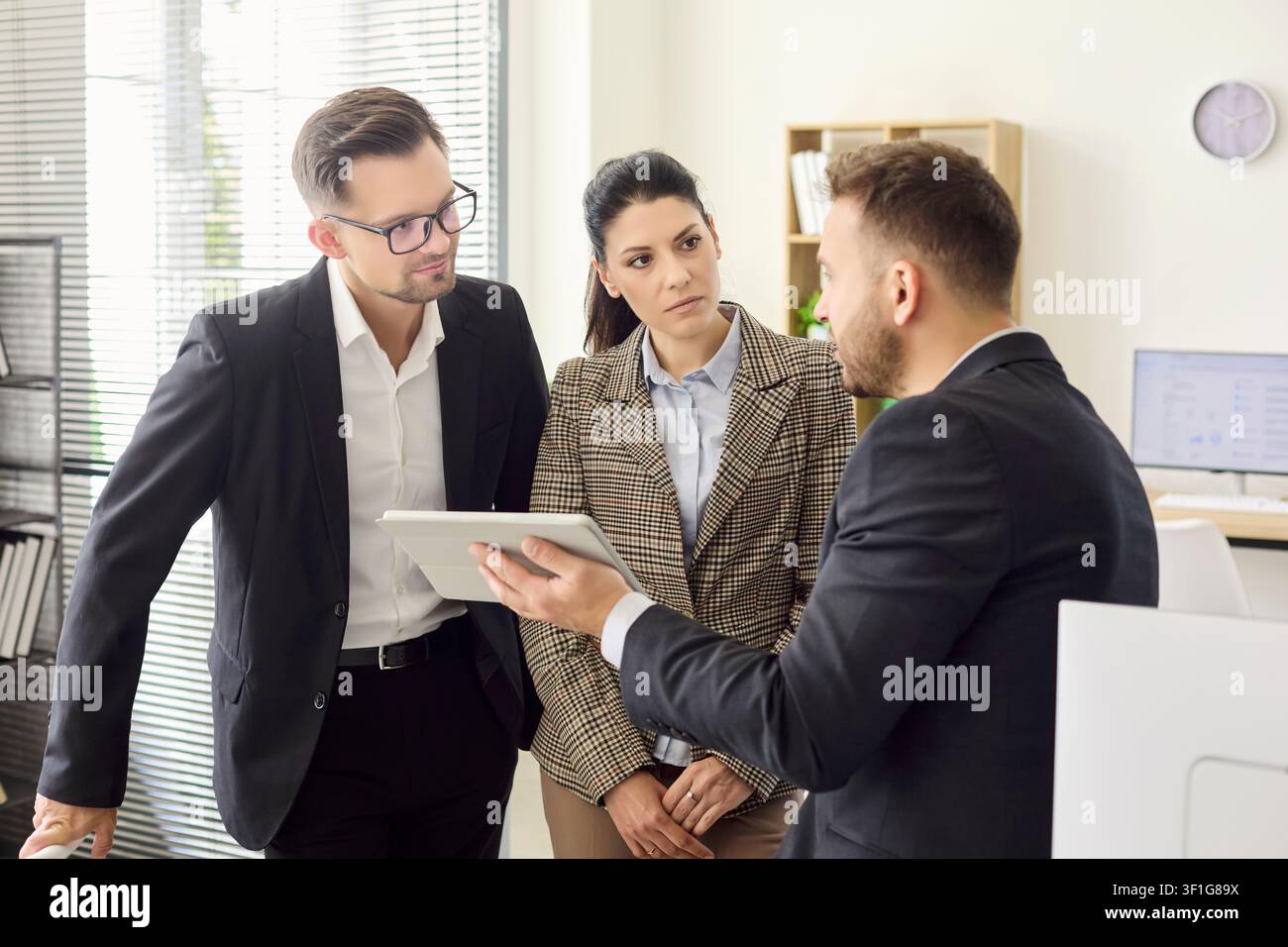 Executives collaborating in office on tablet presentation and strategy meeting Stock Photo